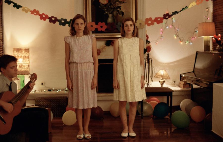 Two girls in dresses at a party.