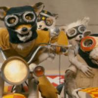 Four anthropomorphic animals wearing goggles and helmets ride motorcycles. The animals appear to be a fox, a rabbit, a badger, and a rat, with the fox in the front and the other three in a sidecar.