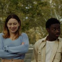 A girl in a blue sweater and a boy in a tan shirt walking side by side.