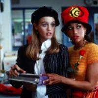 Two people stand in a room with mail slots; one holds a binder while the other holds a rose