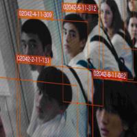 A surveillance photo of a group of high schoolers wearing white shirts each labeled with a red box with a number.