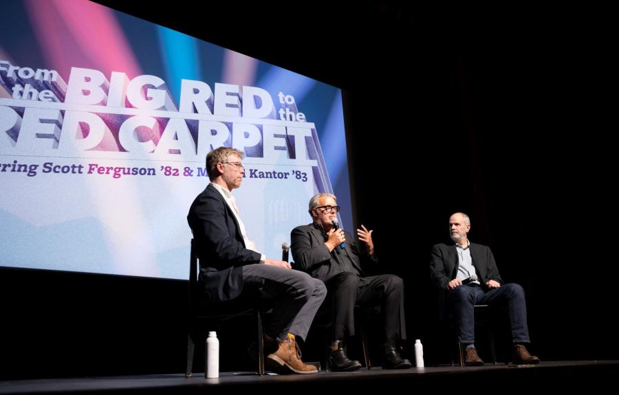 Three men in suits sitting in front of digital screen that reads "From the Big Red to the Red Carpet"