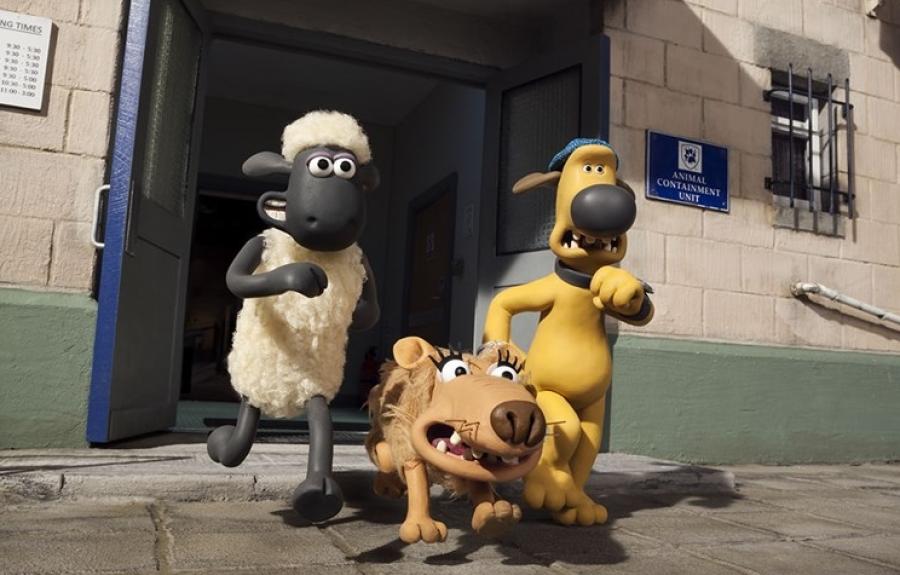 An animated sheep, dog, and wolf are running out of an animal containment building.