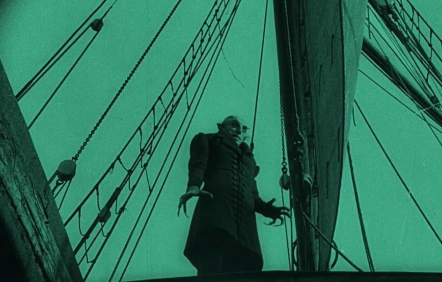 An image of a vampire on a ship tinted in aquamarine.