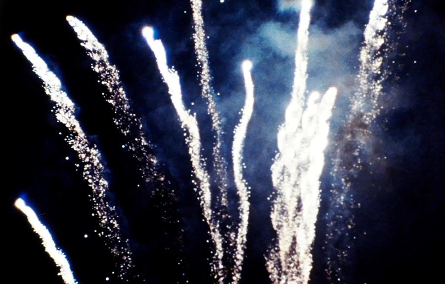 A sparkling shower of spiral fireworks against a night sky.