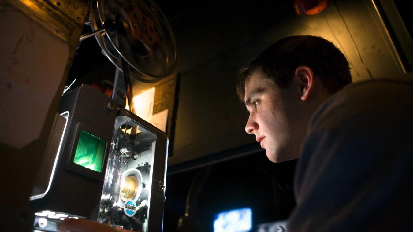 Student working on film projector