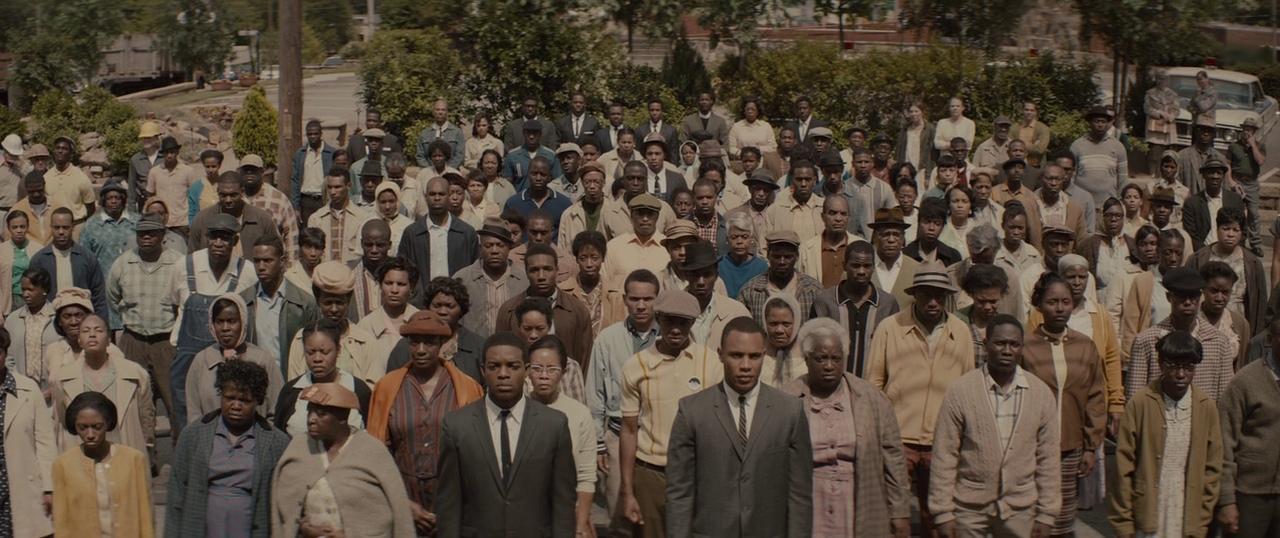 A large group of individuals standing closely together, facing towards the camera. This image depicts a gathering of many people, which could be indicative of an event, protest, or assembly.