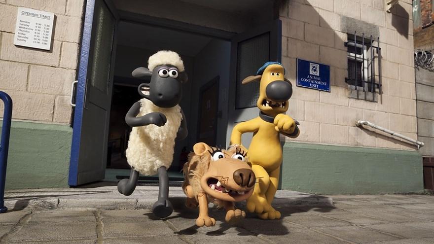 An animated sheep, dog, and wolf are running out of an animal containment building.