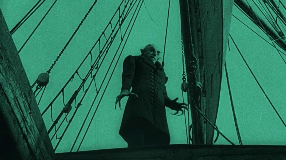 An image of a vampire on a ship tinted in aquamarine.