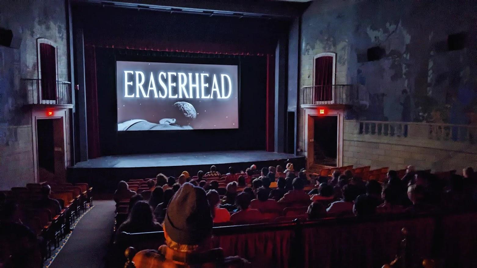 A crowded movie theatre showing the film ERASERHEAD.