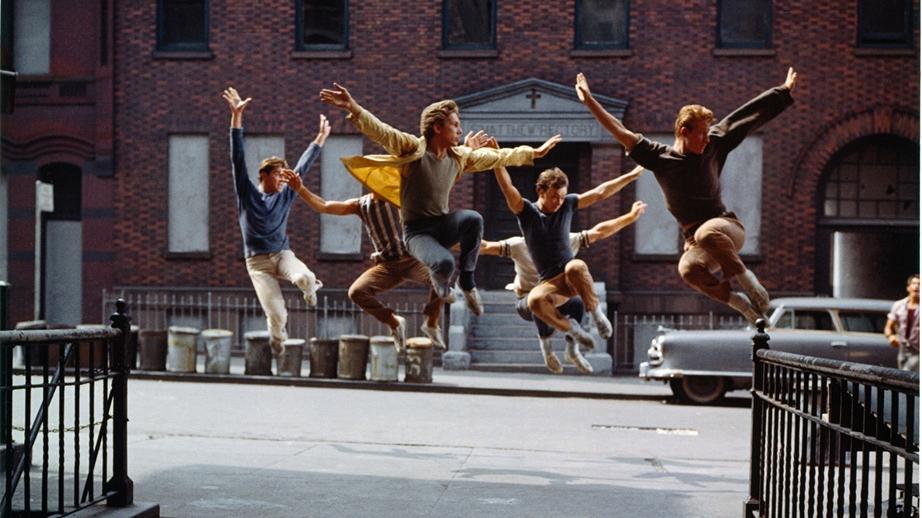 A group of dancing men suspended in mid-air on a city street.
