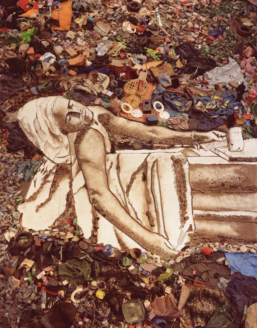 An artists recreation of a photograph using items from a landfill, depicting a person in a reclining position.