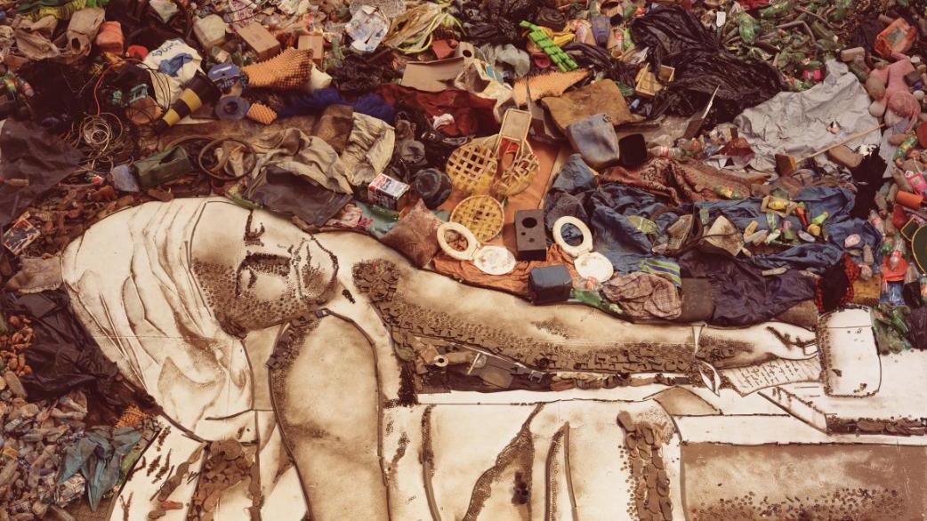 An artists recreation of a photograph using items from a landfill, depicting a person in a reclining position.