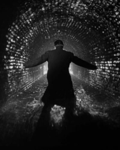 A man running inside a dark tunnel.